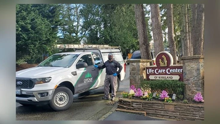 Gilbert Flores of Cascade Pest Control (greater Seattle) in front of residential care facility in Kirkland, WA where COVID-19 first broke out one year ago.