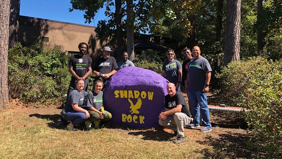 Northwest Exterminating team members in front of Shadow Rock school