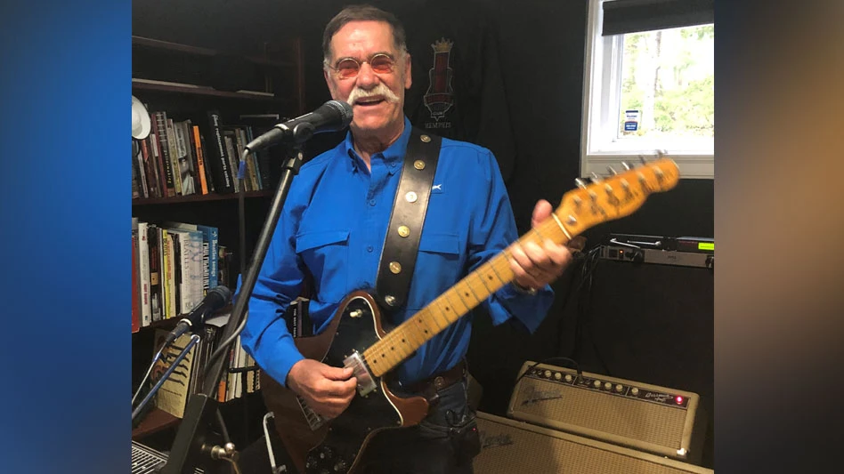 Photo of Don McCarthy playing his guitar