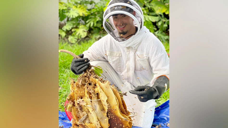 Photo of Jean Loui Navarro with a beehive
