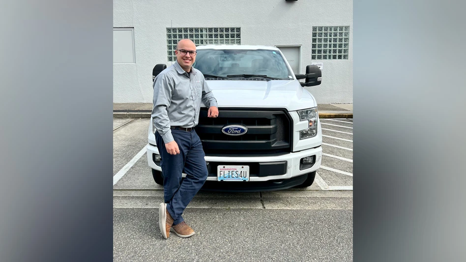 Photo of Tyler Olsson leaning against a truck.