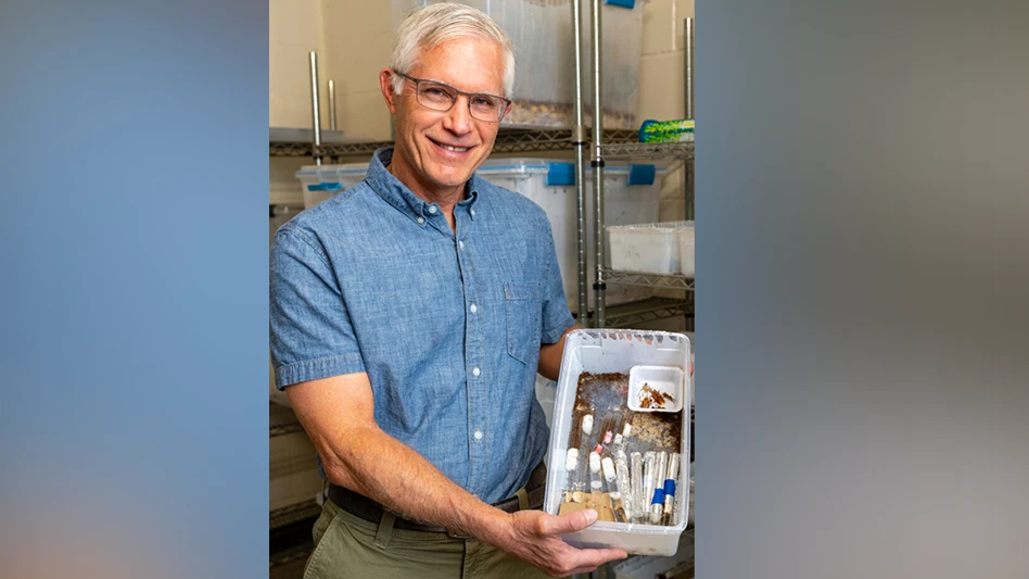 Edward Vargo, Ph.D., with a container of imported red fire ants in his lab.